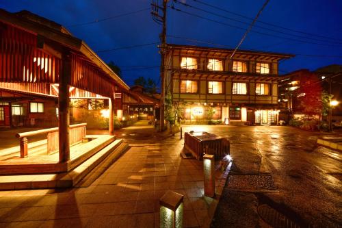 an empty street at night with a building at Ryokan Tamura in Kusatsu