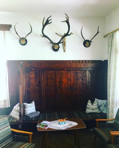 a room with a bench and antlers on the wall at Landhotel Gasthof Eichhof Natters in Innsbruck