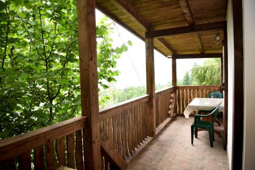 a wooden porch with a table and chairs on it at Casa Edy in Colibiţa