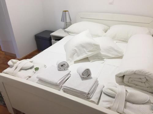 a white bed with towels and pillows on it at Studio apartman Karolina in Karlovac
