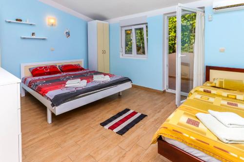 sypialnia z 2 łóżkami i niebieskimi ścianami w obiekcie Apartments Zeko w mieście Donji Morinj