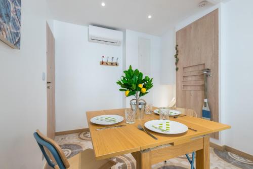 a wooden dining room table with plates and flowers on it at Valbonne Flat in Valbonne