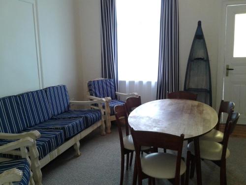 a room with a couch and a table and chairs at Jetty Self-Catering in Swakopmund