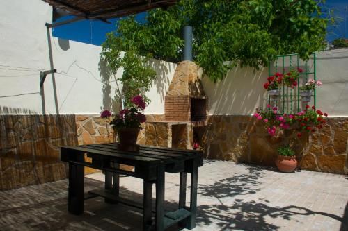 ein Tisch mit Blumen neben einem Steinofen in der Unterkunft Casa Rural Maria Belen in Ruidera