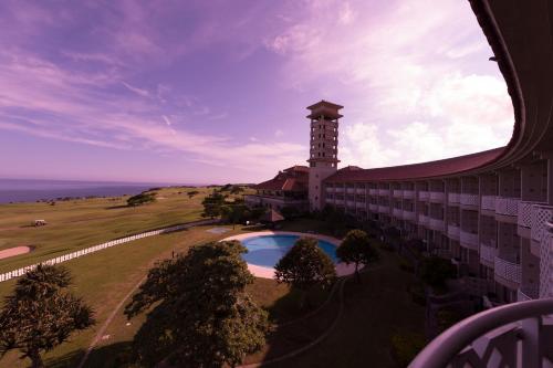 a building with a clock tower and a swimming pool at The Southern Links Resort Hotel in Yaese