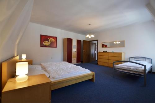 ein Schlafzimmer mit einem großen Bett und einem Tisch mit einer Lampe in der Unterkunft FeWo der Villa Ephraim - Schwarze Straße in Görlitz