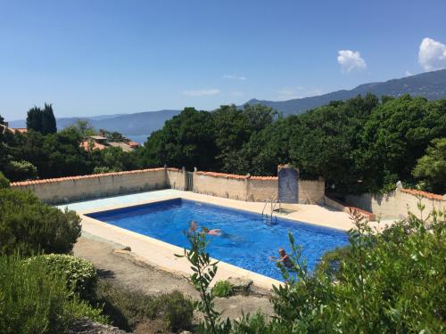 - une piscine dans une villa avec des montagnes en arrière-plan dans l'établissement Les Hameaux de Propriano, à Propriano