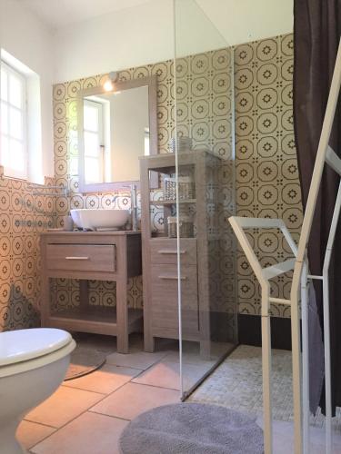 une salle de bain avec toilettes, lavabo et miroir dans l'établissement Les Hameaux de Propriano, à Propriano