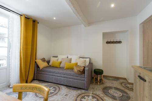 a living room with a couch with yellow curtains at Valbonne Flat in Valbonne