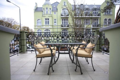 a table and chairs on a balcony with a building at Apartamenty Villa Artis in Świnoujście