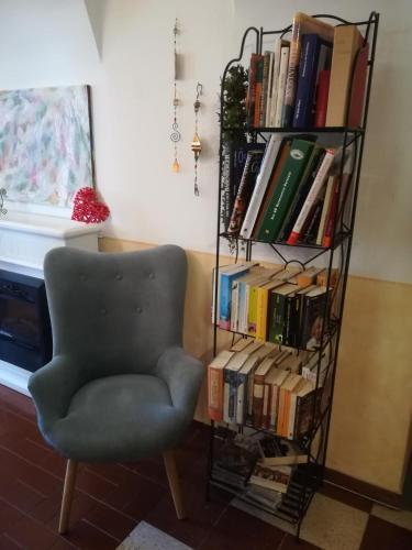 a book shelf filled with books next to a chair at Gästehaus Daurer in Reinsberg