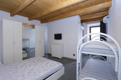 a white bedroom with a bunk bed and a tv at B&B L'Antico Portico in Sorso