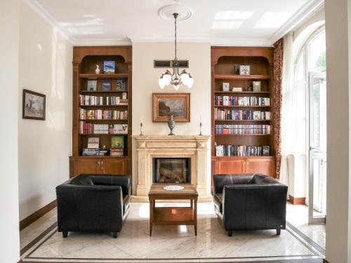 a living room with two chairs and a fireplace at Apartamenty Villa Artis in Świnoujście