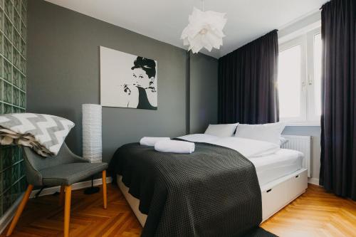 ein Schlafzimmer mit einem Bett und einem Stuhl in der Unterkunft ShortStayPoland Mokotowska (B60) in Warschau