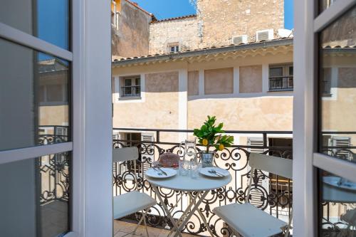 a patio with a table and chairs on a balcony at Valbonne Flat in Valbonne