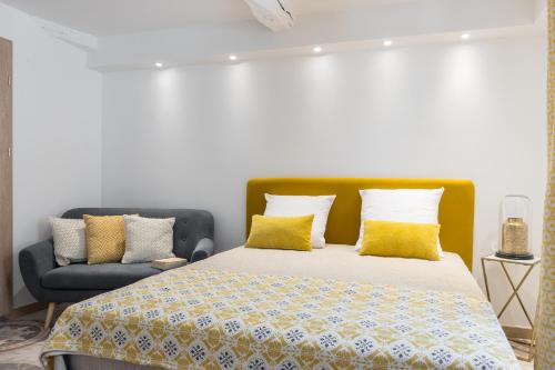 a bedroom with a bed and a blue couch at Valbonne Flat in Valbonne