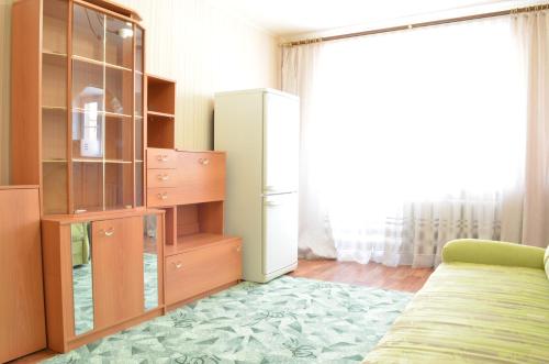 トヴェリにあるApartamenty v tsentreのベッド、ドレッサー、冷蔵庫が備わる客室です。