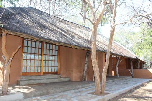 a building with a roof with trees in front of it at Tantebane Game Ranch in Tantebane