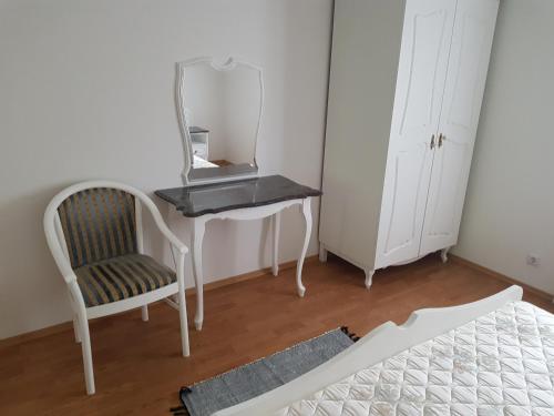 a bedroom with a desk and a chair and a mirror at Favilla Apartmanok2 in Bogács