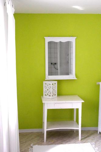 a green room with a white table and a mirror at Landfein Big Country House in Winterberg