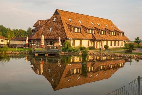 a large building with a reflection in the water at Hotel - Restauracja Platan in Sędziszów Małopolski