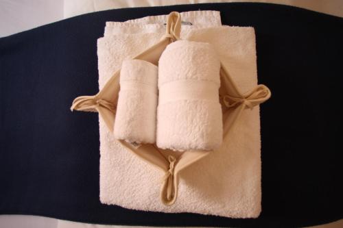two rolled towels on a plate with a ribbon at Numero 3 in Cagliari
