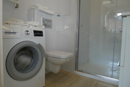 łazienka z pralką i toaletą w obiekcie Impresja 42 Apartament z garażem w Kołobrzegu