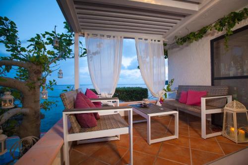 a patio with a couch and a table with a view of the ocean at Il Cefalo Hotel & Restaurant in Castellabate