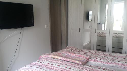 ポゴジェリツァにあるApartament w przy plażyのベッドルーム1室(ベッド1台、壁掛けテレビ付)