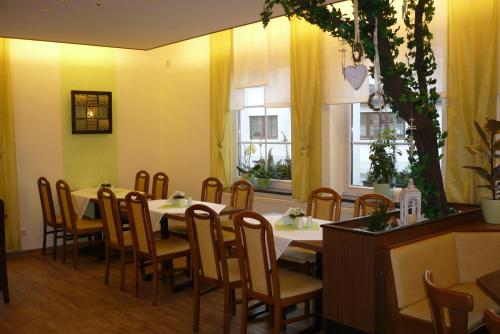 comedor con mesa, sillas y 2 ventanas en Gaststätte & Pension Jiedlitz, en Burkau