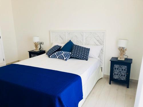 a bedroom with a bed with blue and white pillows at Residence Mar Mediterraneo in Quartu SantʼElena