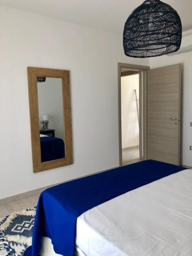 a bedroom with a large bed with a mirror at Residence Mar Mediterraneo in Quartu SantʼElena