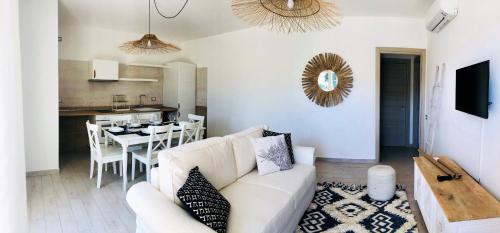 a living room with a white couch and a table at Residence Mar Mediterraneo in Quartu SantʼElena