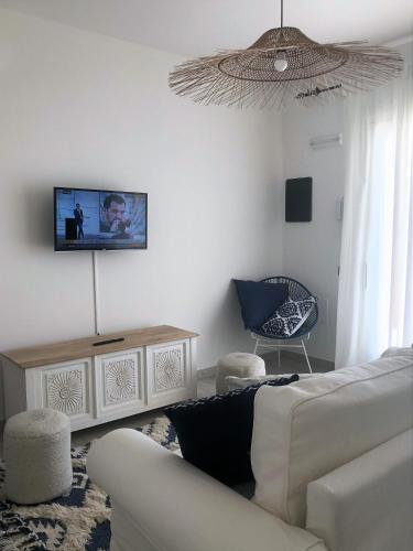 a living room with a couch and a tv on the wall at Residence Mar Mediterraneo in Quartu SantʼElena