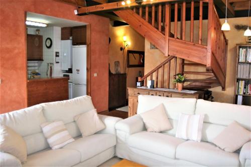 a living room with two white couches and a kitchen at Apartamento Mirador De Masella in Puigcerdà