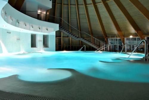 a swimming pool in a building with a staircase at Cró Hotel Rural in Rapoula do Côa