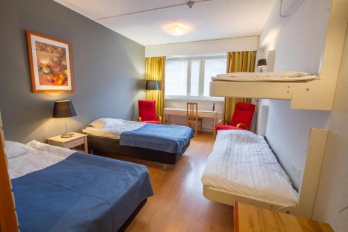 a hotel room with two beds and a desk at Economy Hotel Savonia in Kuopio