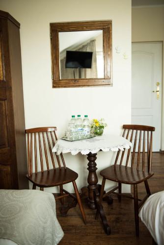 a table with two chairs and a mirror in a room at Lodownia in Szydłowiec
