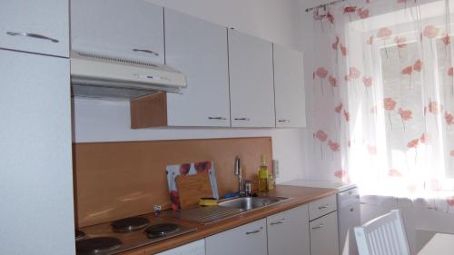 una cocina con armarios blancos y fregadero en Village Appartements, en Waidhofen an der Thaya