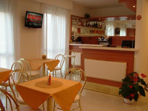 restauracja ze stołami i krzesłami oraz bar w obiekcie Hotel GF w mieście Cesano Boscone