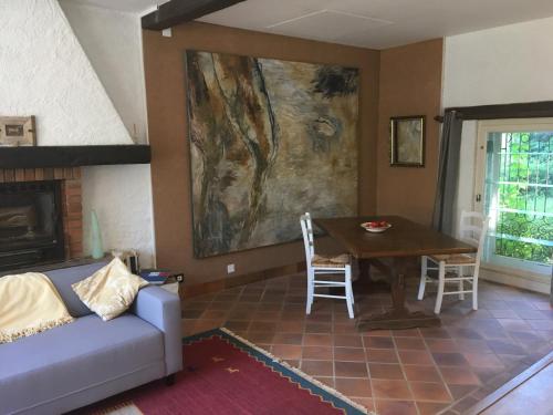 - un salon avec un canapé et une table dans l'établissement Maison Lyre, Pompadour, à Arnac-Pompadour