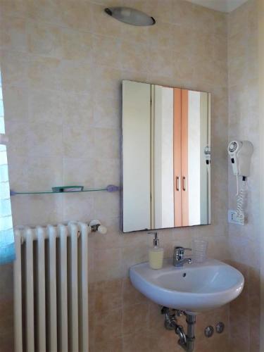 a bathroom with a sink and a mirror and a radiator at Residence Onda Blu in Cervia