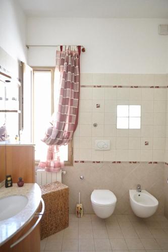 a bathroom with a toilet and a sink at Baciata Dal Sole Home in Monopoli