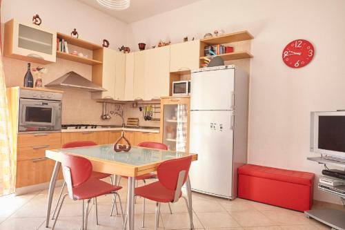 cocina con mesa, sillas y nevera en Baciata Dal Sole Home en Monopoli