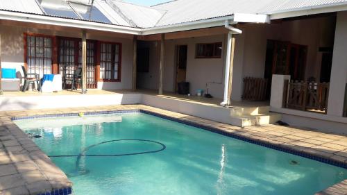 a swimming pool in front of a house at Jacaranda Guesthouse in Eshowe