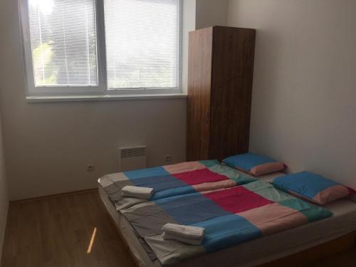 a bedroom with a bed with a colorful blanket at Hotel Můstek in Liberec