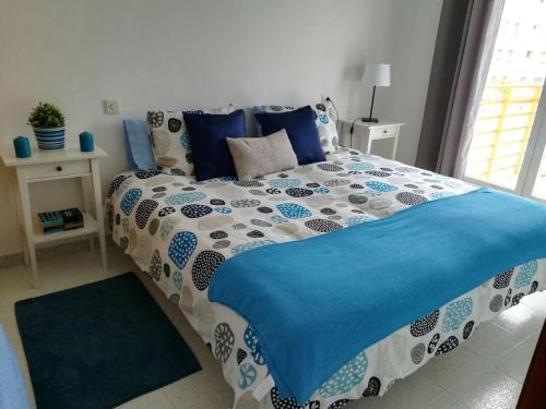 1 cama con edredón azul y blanco en un dormitorio en Cambrils, en Cambrils
