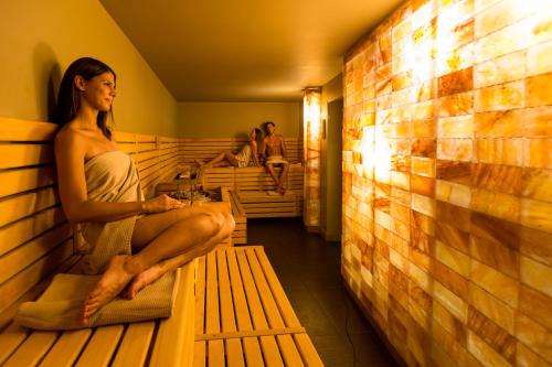 a woman sitting on a bench in a bleachers at Terme Tuhelj Hotel Well in Tuheljske Toplice