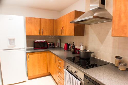 a kitchen with wooden cabinets and a stove top oven at Boutique Home from Home in London