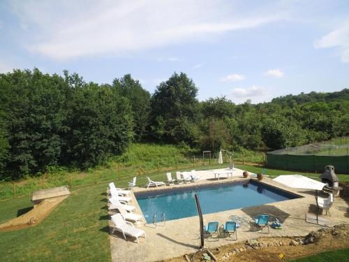 a large swimming pool with lounge chairs in a yard at La Morona in Rocchetta Tanaro